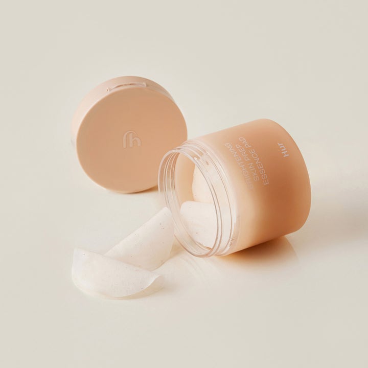 House of Hur Brightening Skin Prep Essence Pad 140 ml kirkastava kasvovesi persikanvärisessä purkissa ja valkoisia lappuja.