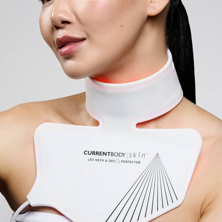 Currentbody Skin Neck and Dec Perfector valkoinen LED-valohoitolaite kaulalla ja dekolteella punavalolla.