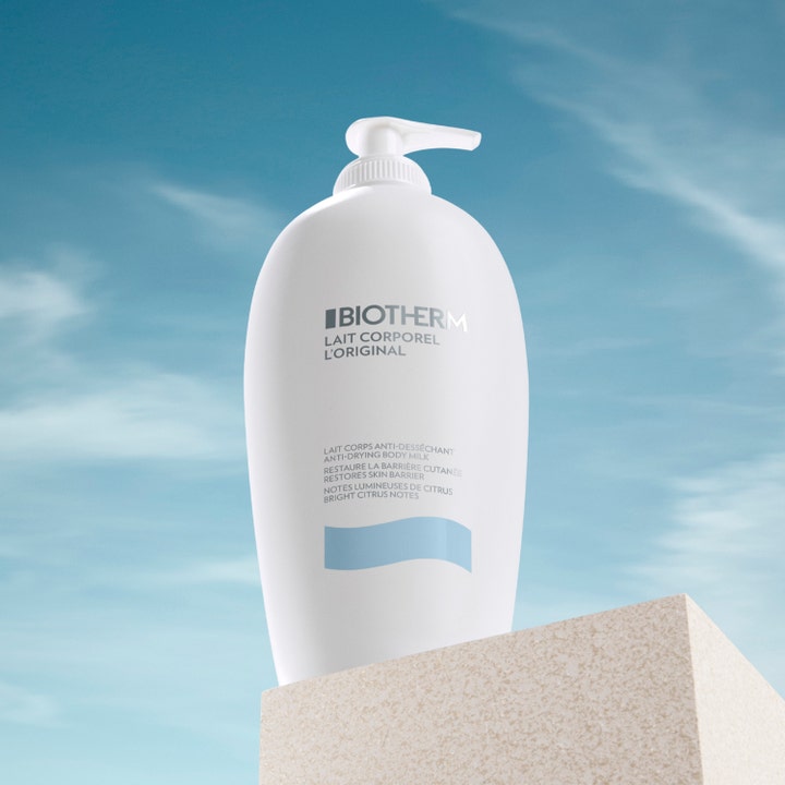 Biotherm Lait Corporel 400 ml kosteuttava vartalovoide valkoisessa pumppupullossa kivijalustalla taivasta vasten