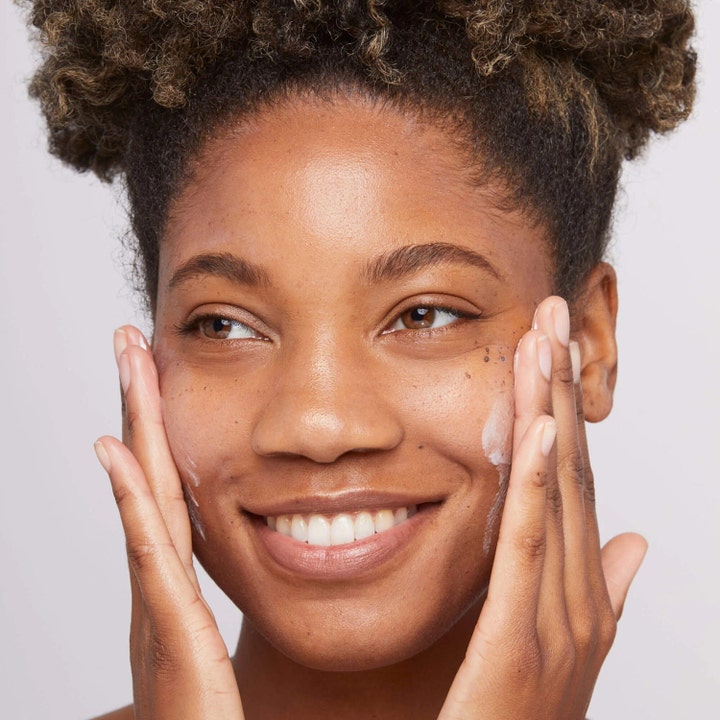 Dermalogica Skin Smoothing Cream 15 ml kosteuttava kasvovoide levitettynä hymyilevän henkilön poskille