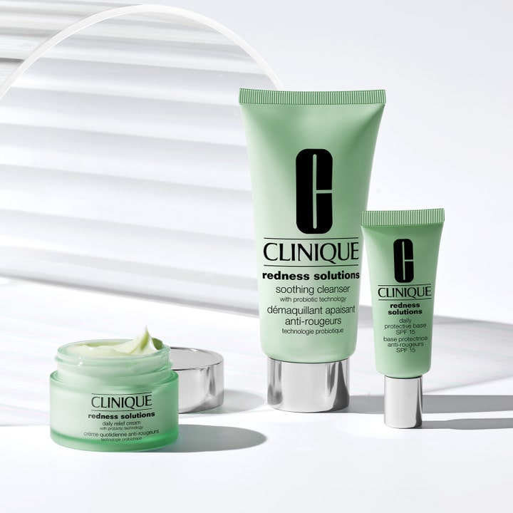 Clinique Redness Solutions Daily Relief Face Cream 50 ml rauhoittava kasvovoide avatussa purkissa ja sarjan vihreät tuubit.