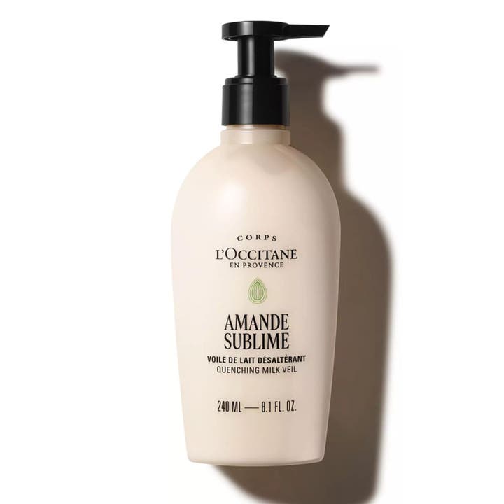 L'Occitane Amande Milk Veil 240 ml kosteuttava ja silottava vartalovoide valkoisessa hopeakaulaisessa pumppupullossa.