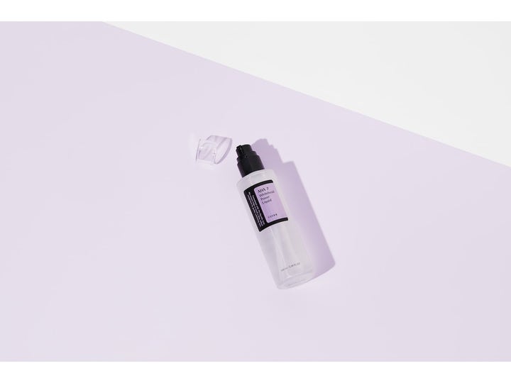 COSRX AHA 7 Whitehead Power Liquid 100 ml kirkastava kasvovesi huurteisessa pumppupullossa lilaa taustaa vasten