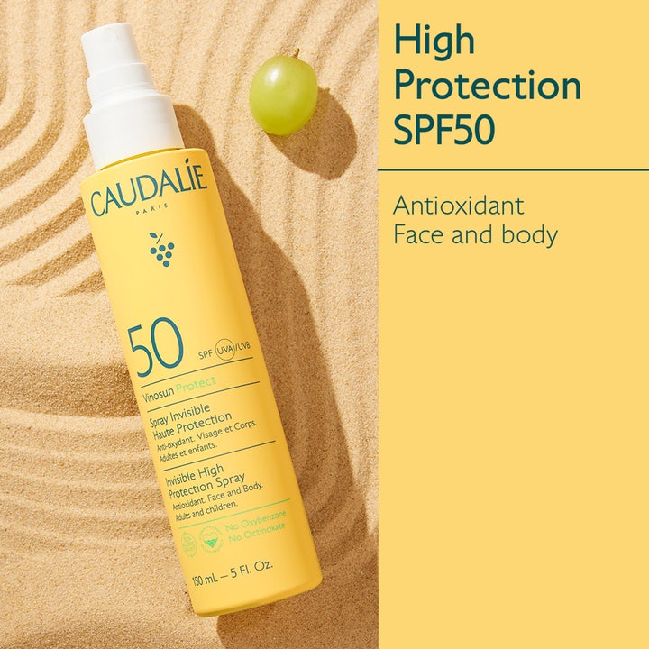 Caudalie Vinosun High Protection Spray SPF50 150 ml antioksidanttinen aurinkosuojasuihku keltaisessa pullossa hiekalla