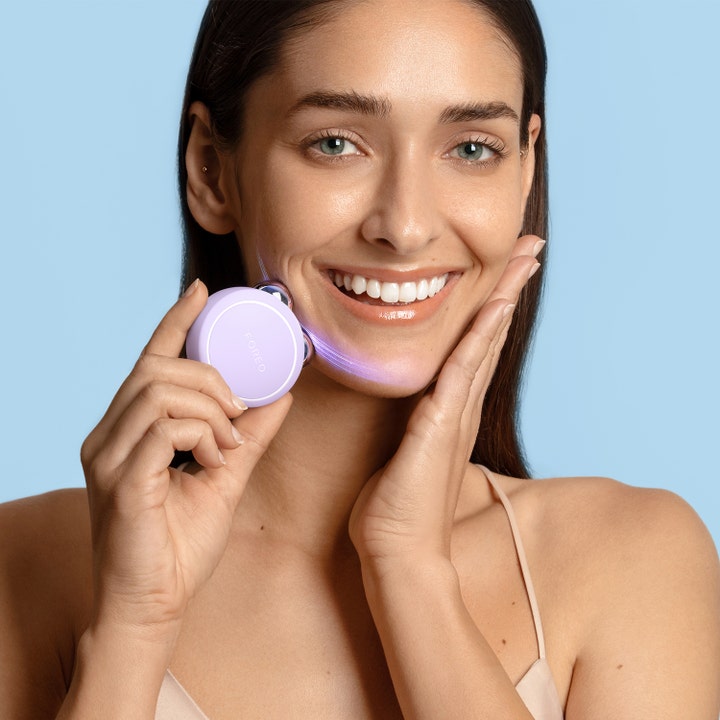 FOREO BEAR 2 go Lavender 1 kpl kiinteyttävä mikrovirtalaite jota nainen käyttää leualla valoefektin kera.