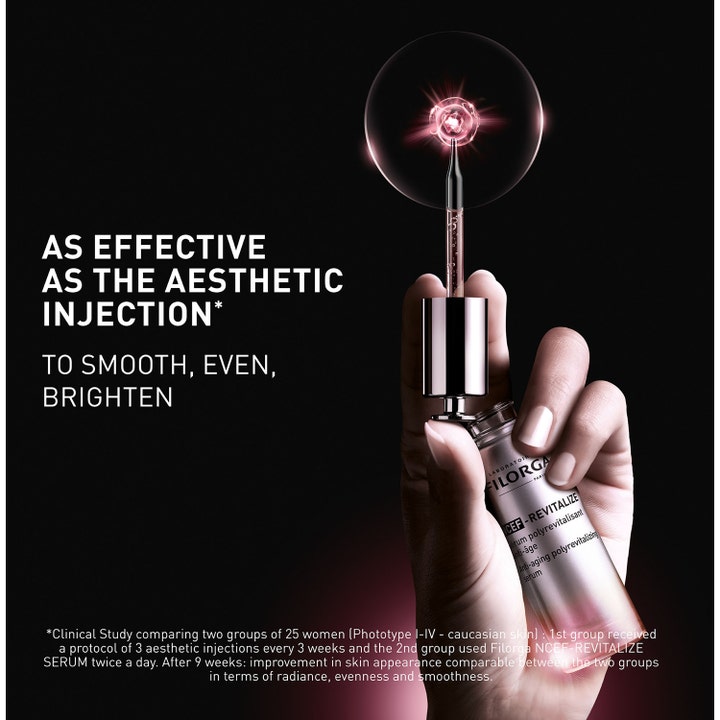 Filorga NCEF-Revitalize Serum 30 ml heleyttÀvÀ seerumi kÀdessÀ ja pipetti vaaleanpunaisella valolla.
