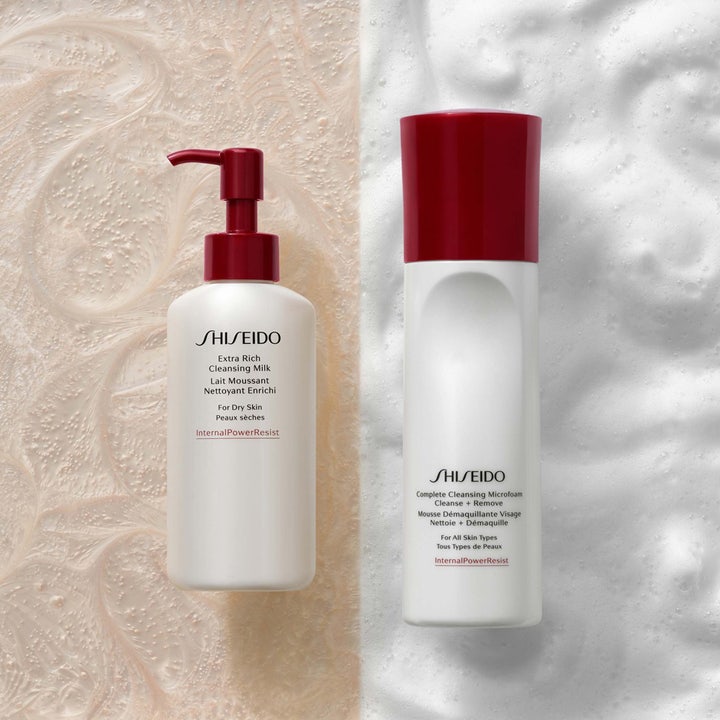 Shiseido Defend Preparation Cleansing Microfoam 180 ml puhdistusvaahto valkoisessa pullossa vaahtoisella taustalla.