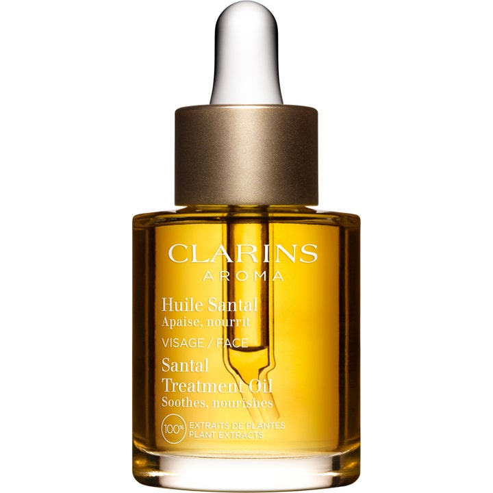 Clarins Santal Treatment Oil rauhoittava kasvoöljy kirkkaassa lasipullossa jossa on kultainen öljy ja pipetti