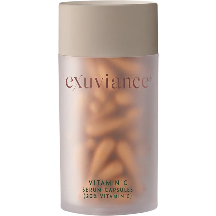 Exuviance Vitamin C Serum Capsules kirkastava seerumi huurteisessa purkissa, jossa on kultaisia kapseleita.