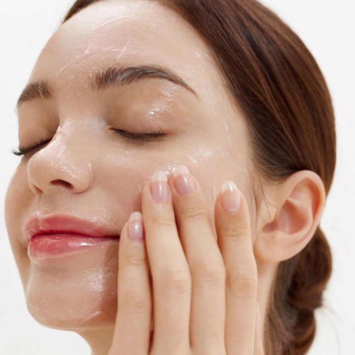 House of Hur Purifying Cleansing Balm 50 ml puhdistusbalmi jota nainen hieroo kasvoilleen poistaakseen epäpuhtaudet.