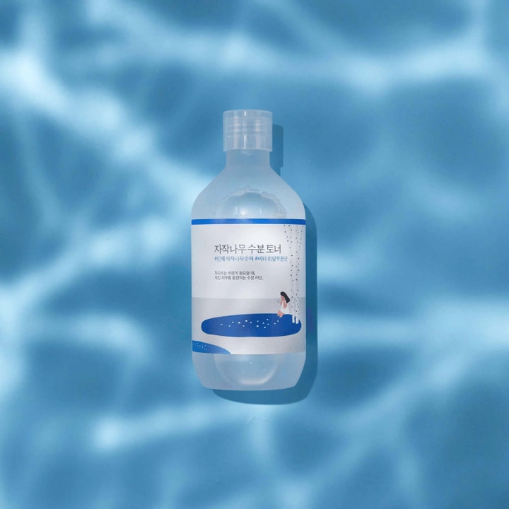 Round Lab Birch Juice Moisturizing Toner 300 ml kosteuttava kasvovesi huurteisessa pullossa veden väreiden päällä.