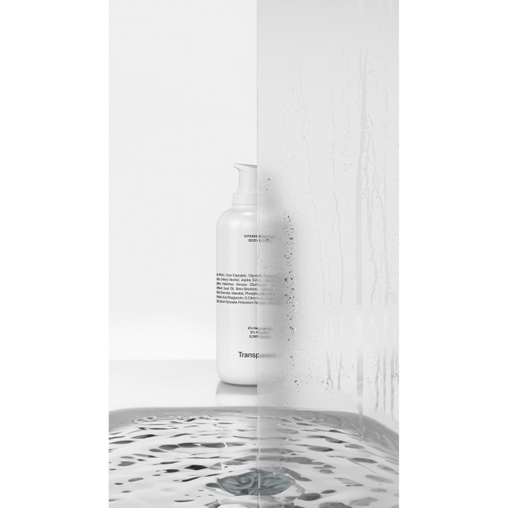 Niche Beauty Lab Transparent Lab Vitamin Enriched Body Lotion 400 ml vartalovoide valkoisessa pullossa märän lasin läpi.
