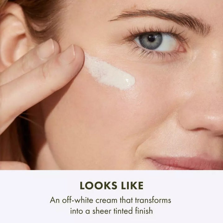 Origins GinZing SPF40 Energy-Boosting Tinted Moisturizer 50 ml sävyttävä päivävoide nainen pitelee oranssia tuubia