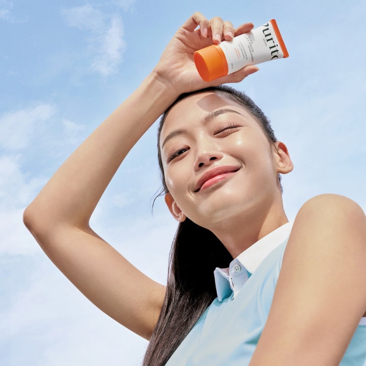 Purito Daily Soft Touch Sunscreen 60 ml SPF 50+ aurinkovoide kasvoille suojaavilla keramideilla oranssilla taustalla.