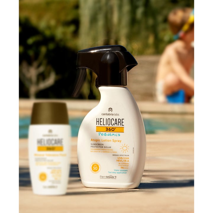 Heliocare Pediatrics Atopic Lotion Spray SPF 50 250 ml aurinkosuoja lapselle uima-altaan reunalla