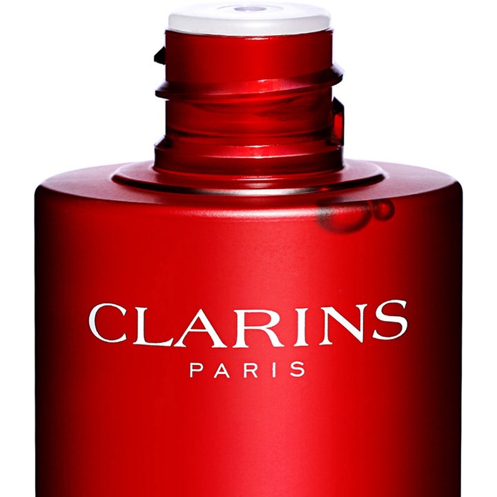 Clarins Super Restorative Treatment Essence 200 ml uudistava hoitovesi punaisessa pullossa valkoisella tekstillä.