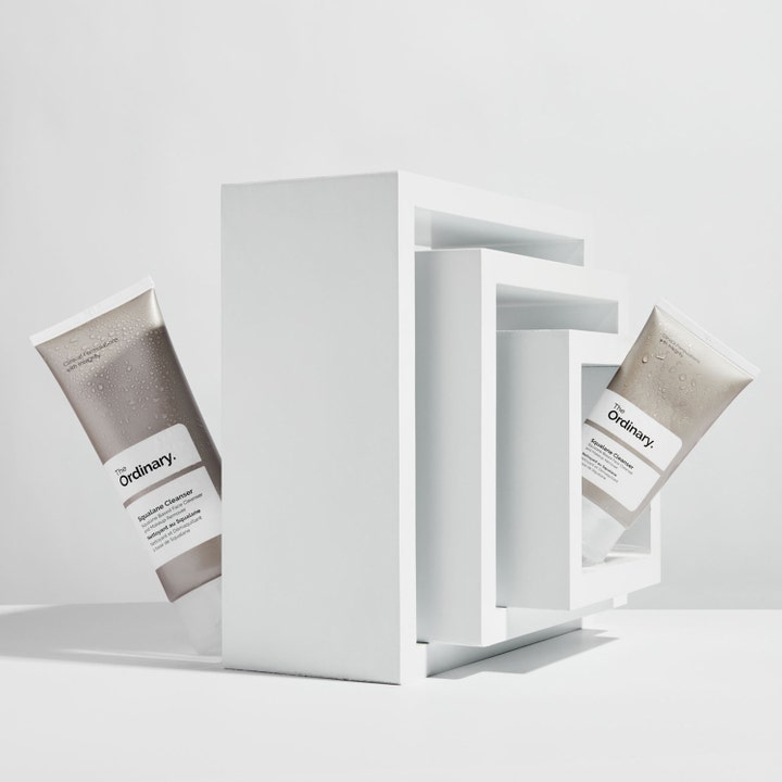 The Ordinary Squalane Cleanser 150 ml kosteuttava puhdistusaine kaksi vesipisaraista tuubia valkoisissa kehyksissä