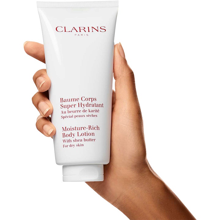Clarins Moisture-Rich Body Lotion 200 ml kosteuttava vartalovoide kädessä pidetyssä valkoisessa tuubissa