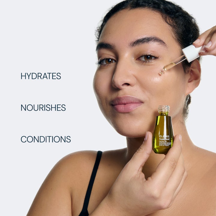 Elemis Superfood Facial Oil 15 ml kosteuttava kasvoöljy pipetillä naisen kasvoille levitettynä.