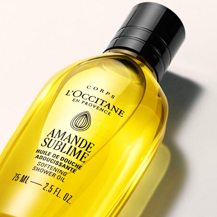 L'Occitane en Provence Almond Shower Oil 75 ml pehmittävä suihkuöljy kirkkaassa pullossa jossa on kultaista öljyä
