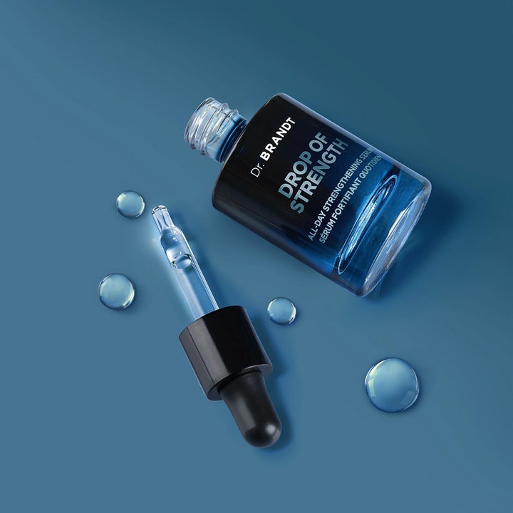 Dr Brandt Drop Of Strength 30 ml vahvistava kasvoseerumi sinisessä lasipullossa kirkkaiden pisaroiden ja pipetin kera.