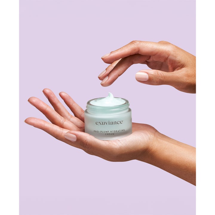 Exuviance Pro-Plump Hydrating Cream 45 g kosteuttava yövoide kädessä vaaleansinistä voidetta lasipurkissa